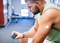 Junger Mann mit Dexcom G7 Sensor und t:slim X Insulinpumpe.